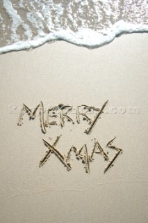 Merry Christmas Xmas sign writing message on a sandy beach in Tarifa, Spain, near Gibraltar.