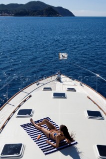 A romantic couple relaxing onboard a Vicel 72 classic motor yacht.  Model Released.