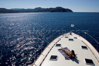 A romantic couple relaxing onboard a Vicel 72 classic motor yacht.  Model Released.