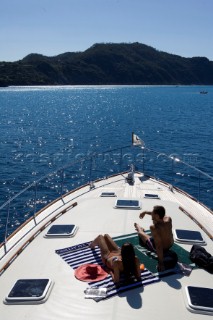 A romantic couple relaxing onboard a Vicel 72 classic motor yacht.  Model Released.