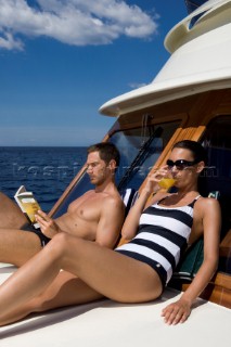 A romantic couple relaxing onboard a Vicel 72 classic motor yacht.  Model Released.