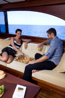 A romantic couple relaxing onboard a Vicel 72 classic motor yacht.  Model Released.