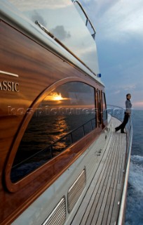 A romantic couple relaxing onboard a Vicel 72 classic motor yacht.  Model Released.