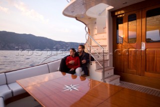 Lifestyle couple onboard a Vicem 72 classic motor yacht in the sunset Model Released.