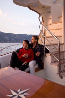 Lifestyle couple onboard a Vicem 72 classic motor yacht in the sunset Model Released.