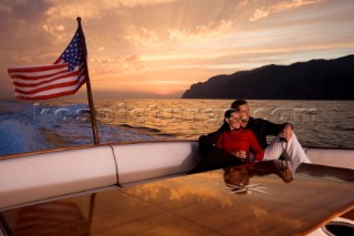 Lifestyle couple onboard a Vicem 72 classic motor yacht in the sunset Model Released.