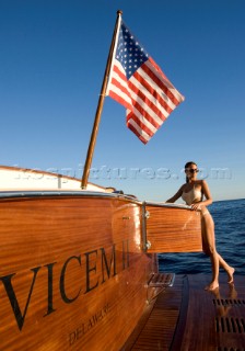 Lifestyle female onboard a Vicem 72 classic motor yacht in swimsuit on swim platform about to take a swim Model Released.