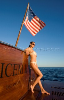 Lifestyle female onboard a Vicem 72 classic motor yacht in swimsuit on swim platform about to take a swim Model Released.