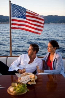 Lifestyle couple having drinks and coctails onboard a Vicem 72 classic motor yacht in the sunset Model Released.