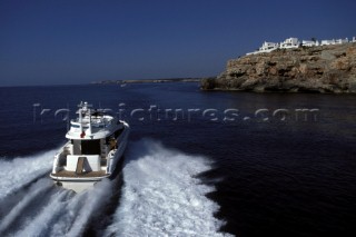 A Fairline powerboat speeds through the water leaving wash