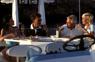 Couples enjoying a meal on deck of a Fairline powerboat