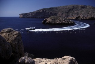 A Fairline powerboat speeds through the water leaving wash