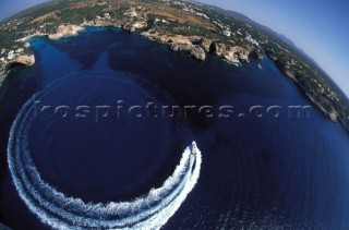 A Fairline powerboat speeds through the water leaving wash