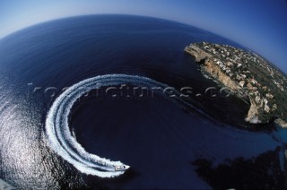 A Fairline powerboat speeds through the water leaving wash