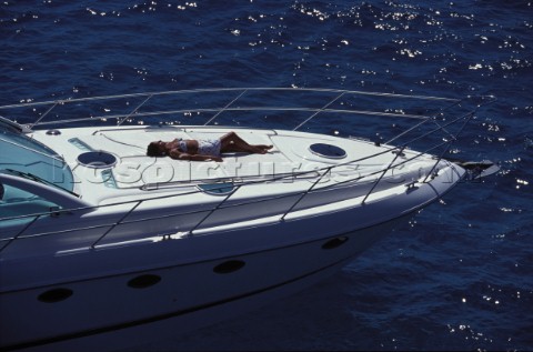 Woman sunbathing on foredeck of Fairline Targa 48