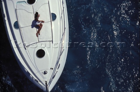 Woman sunbathing on foredeck of Fairline Targa 48