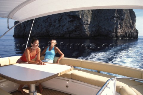 Two female passengers sitting on table at stern of Squadron 58