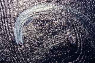 Dinghy drives in a circle around moored sailing yacht