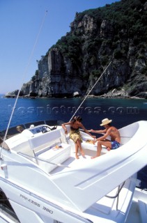 Romantic couple relaxing playing chess on the flybridge of a Princess 380