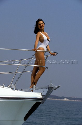 Sexy girl female model in white swimsuit onboard powerboat