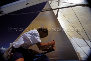 Crew member trimming sail on winch