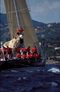 Crew member is hoisted up the mast to help lower a damaged mainsail