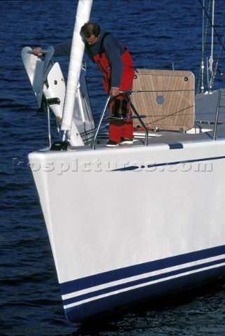 Man raising anchor on luxury Swan 80 cruising yacht