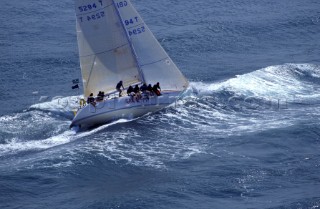 Racing yacht crashing through choppy waves in the Solent, UK