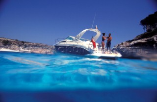 Male and female models relaxing and socialising on a luxury Fairline powerboat