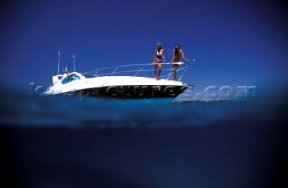 Male and female models relaxing and socialising on a luxury Fairline powerboat