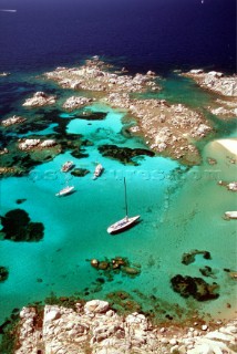 Aerail view of yacht anchored by secluded beach