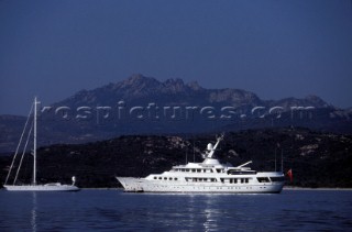 Cruising superyacht at anchor in a quiet anchorage mooring