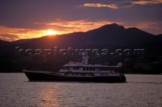 Cruising superyacht at anchor in a quiet anchorage mooring