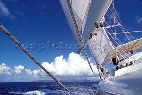 Skipper trims the giant sails onboard a superyacht in the tropics