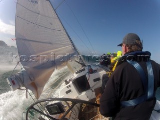 Helmsman driving upwind in rough seas onboard the Norwegian J133 Madjus during the JP Morgan Round the Island Race 2012 by The Needles