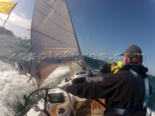 Helmsman driving upwind in rough seas onboard the Norwegian J133 Madjus during the JP Morgan Round the Island Race 2012 by The Needles