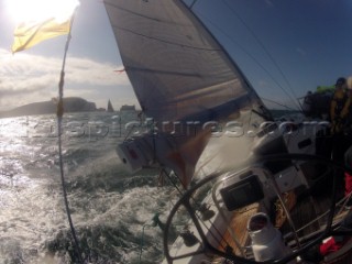 Helmsman driving upwind in rough seas onboard the Norwegian J133 Madjus during the JP Morgan Round the Island Race 2012 by The Needles