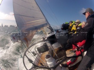 Helmsman driving upwind in rough seas onboard the Norwegian J133 Madjus during the JP Morgan Round the Island Race 2012 by The Needles