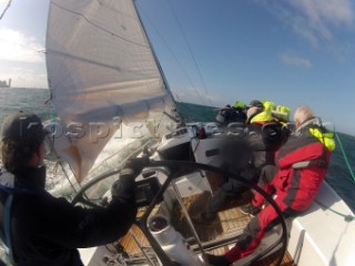 Helmsman driving upwind in rough seas onboard the Norwegian J133 Madjus during the JP Morgan Round the Island Race 2012 by The Needles