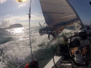 Helmsman driving upwind in rough seas onboard the Norwegian J133 Madjus during the JP Morgan Round the Island Race 2012 by The Needles