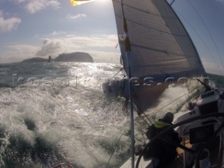 Helmsman driving upwind in rough seas onboard the Norwegian J133 Madjus during the JP Morgan Round the Island Race 2012 by The Needles