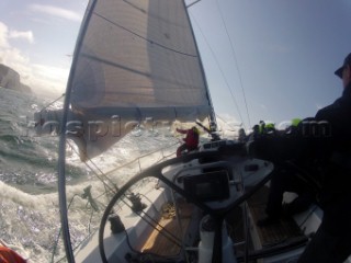 Helmsman driving upwind in rough seas onboard the Norwegian J133 Madjus during the JP Morgan Round the Island Race 2012 by The Needles