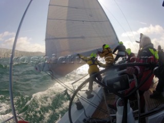 Helmsman driving upwind in rough seas onboard the Norwegian J133 Madjus during the JP Morgan Round the Island Race 2012 by The Needles