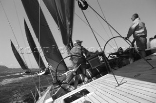 Luca Bassani, the Italian businessman, entrepreneur and owner of Wally Yachts, helms his copper-coloured canting keel yacht Tikatitoo on the layline to the next mark of the race course, under the supervision of Americaâ€™s Cup tactician Tom Whidden. The layline is the optimal imaginary course which the yacht must take to get to itâ€™s destination â€“ normally the next mark or the finish - in the shortest possible time. Judging the position of the imaginary layline from several miles out, with or without electronic aids and computers, whilst compensating for the constant shifts in the current and the wind, is a precise skill mastered by only the most senior of helms and tacticians. Luca Bassani is himself a past World Champion. Maxi Yacht Rolex Cup 2001. Porto Cervo, Sardinia.