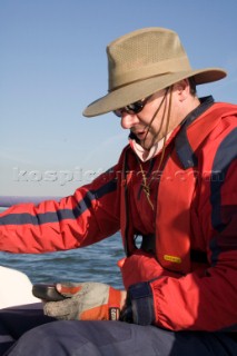 Male navigator using GPS to sail in a yacht race Round the Island Race on a J80 sportsboat