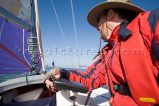 Male navigator using GPS to sail in a yacht race Round the Island Race on a J80 sportsboat