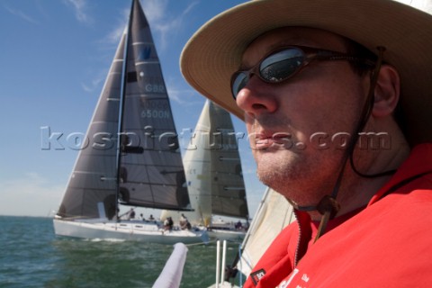 Male navigator using GPS to sail in a yacht race Round the Island Race on a J80 sportsboat