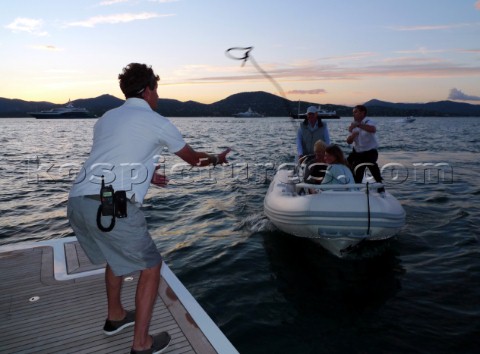 Crew prepare for tender to arrive with guests at the stern of a motoryacht superyacht in the Mediter