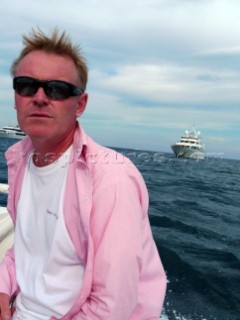 Man in tender returning to superyacht in the Mediterranean