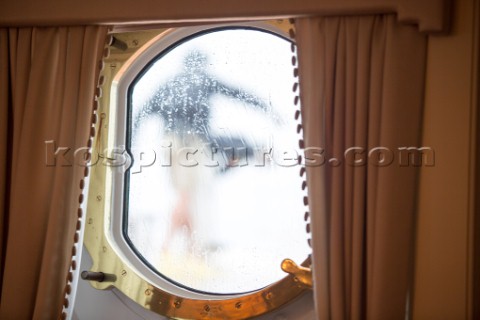 Crew seen through a porthole onboard superyacht Talitha